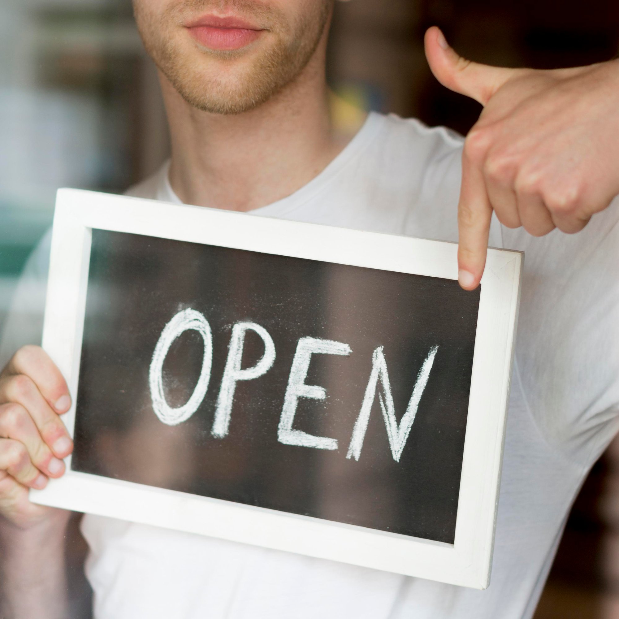 man-holding-pointing-open-coffee-shop-sign man-holding-pointing-open-coffee-shop-sign